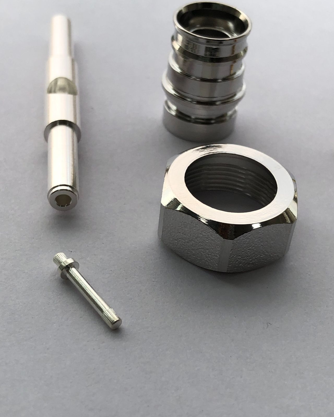 Tri-metal plated RF connector parts: a connector body, a hex coupling nut and two pins
